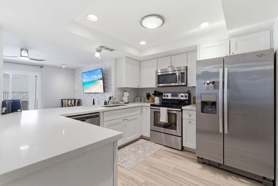 Gather in the bright, open kitchen with stainless steel appliances and a breakfast bar, perfect for morning coffee, easy meals, and happy-hour bites.