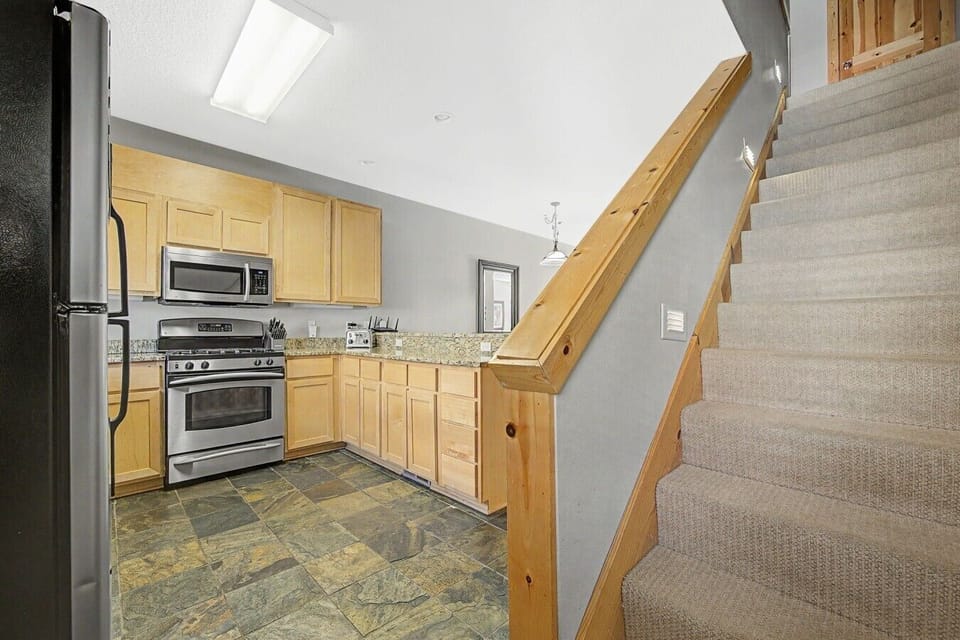 Kitchen view featuring the staircase leading to the third floor, where both bedrooms are located.