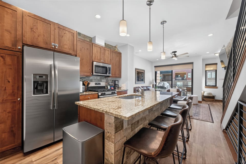 Your spacious kitchen awaits with granite countertops, stainless steel appliances, and a breakfast bar perfect for morning coffee conversations.