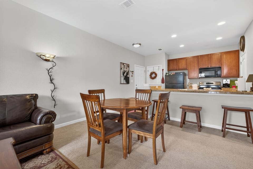 Gather around your dining table in this bright open space, where warm wood tones and a welcoming kitchen bar invite easy mornings and memorable meals together.