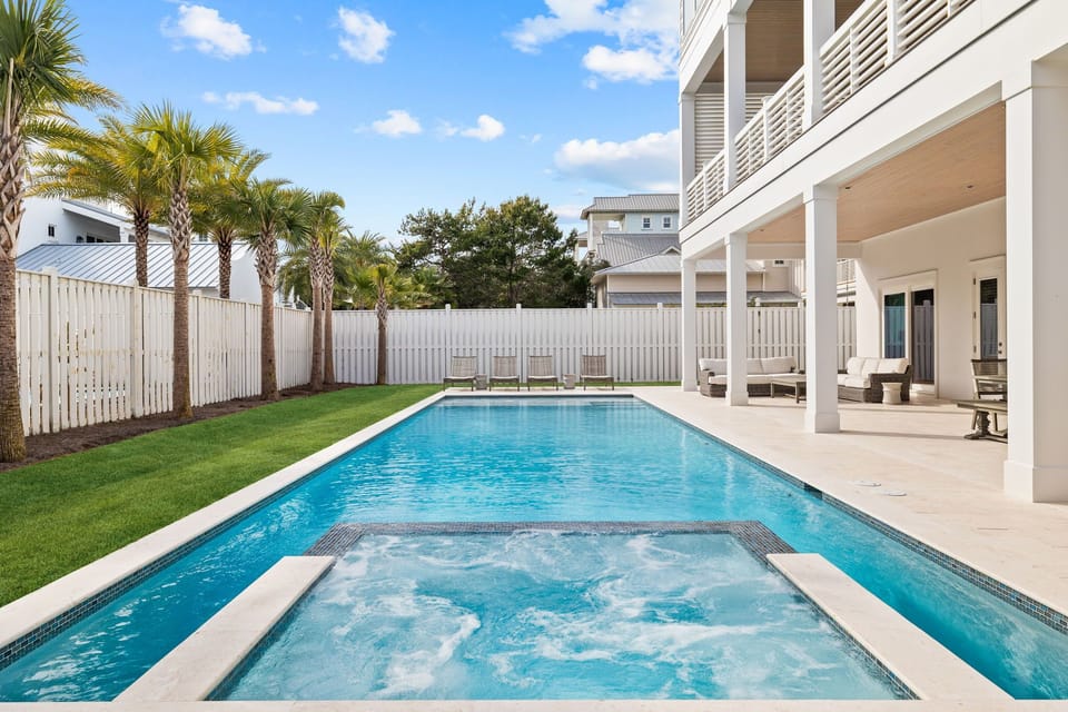 Step into your private oasis with a sparkling pool, bubbling hot tub, and lush tropical palms framing a perfectly manicured lawn—your ideal sunny escape awaits.