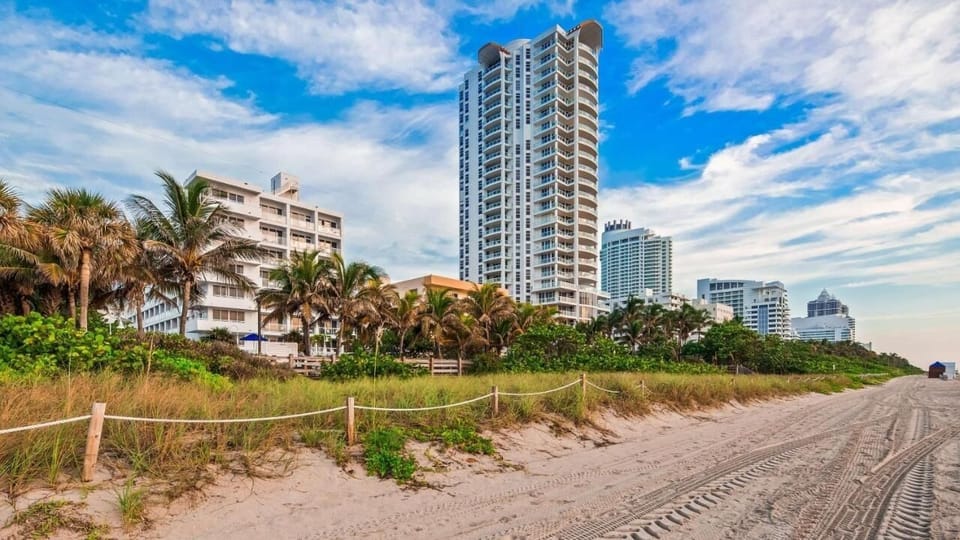 Wake up to ocean breezes beside a sunlit beachfront skyline.