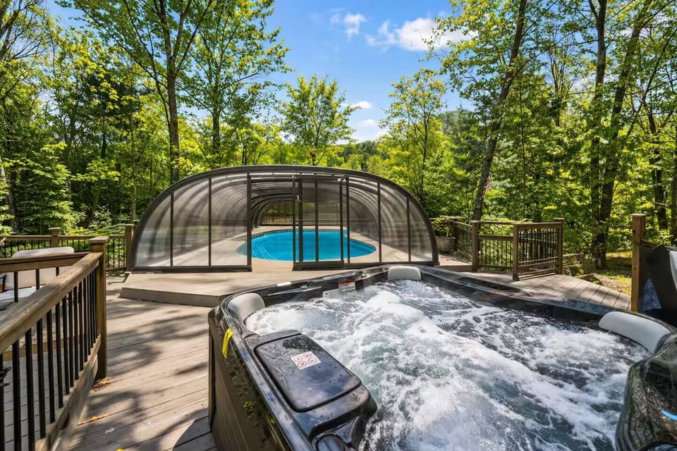 Relax in the private outdoor hot tub overlooking the trees, steps from the pool and lounge area. Perfect for unwinding after a day of adventure-ideal year-round for cozy evenings under the stars.