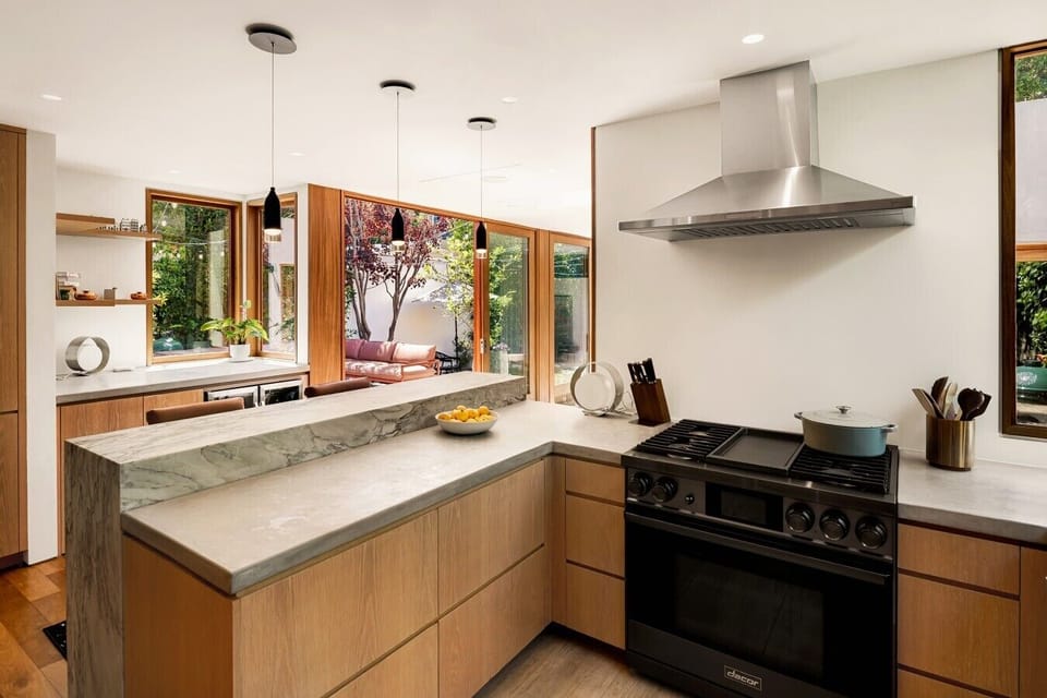 A fully equipped chef`s kitchen with gas range, marble countertops, and garden views — everything you need to cook, gather, and linger.