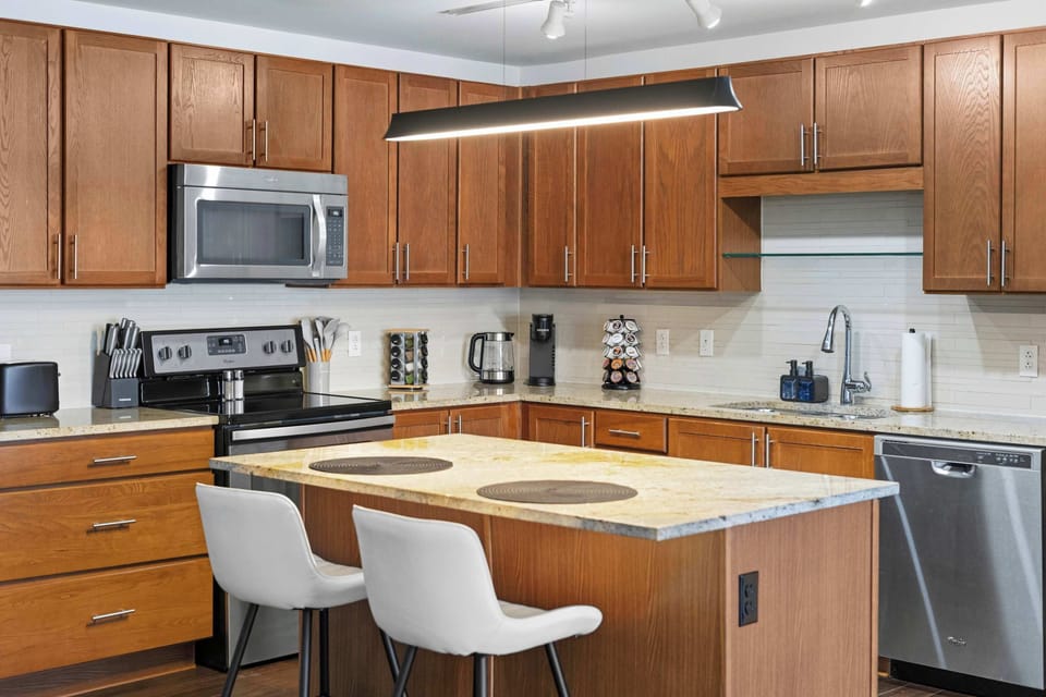 Fully equipped kitchen with stainless steel appliances, island seating, and plenty of counter space.