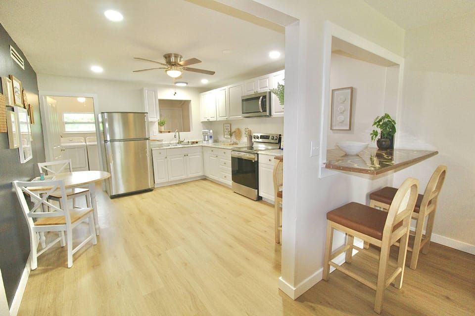 The gorgeous open kitchen boasts stainless steel appliances and plenty of space to prep, cook and dine.