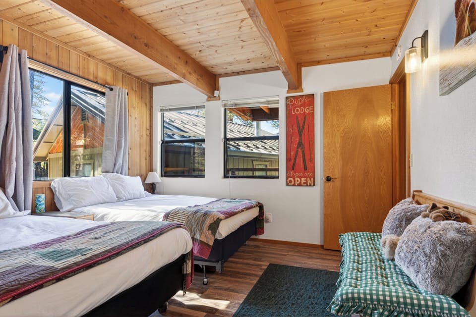 Another angle of the secondary bedroom showcasing its spacious layout and classic mountain cabin character.