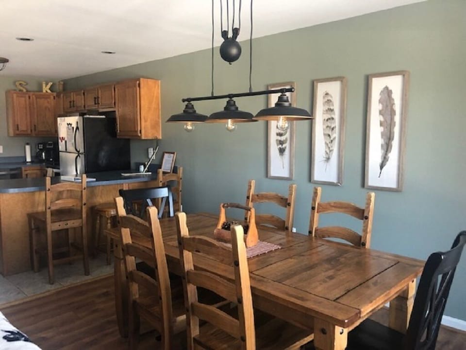 Gather around for shared meals in the warm dining area, with rustic wood accents and an open flow into the kitchen.