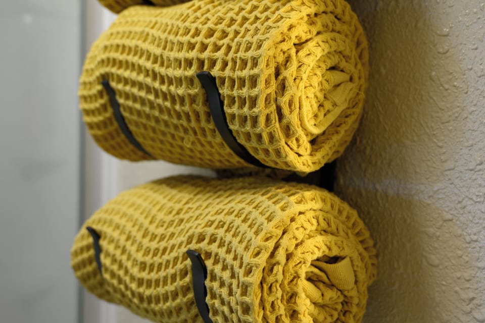 Cozy golden waffle-weave towels await your arrival at 1126 Western Road , perfectly folded and ready to wrap you in comfort after your refreshing shower.