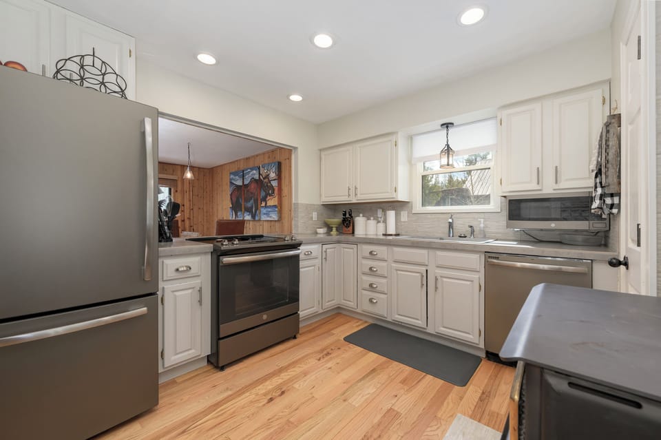 Your fully equipped kitchen at 1126 Western Road features modern appliances, granite counters, and warm wood floors—perfect for preparing memorable meals during your stay.
