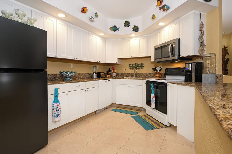 Step into your spacious, fully-equipped kitchen with granite counters, modern appliances, and playful coastal décor. Plenty of room to whip up fresh vacation meals or morning coffee before the beach.