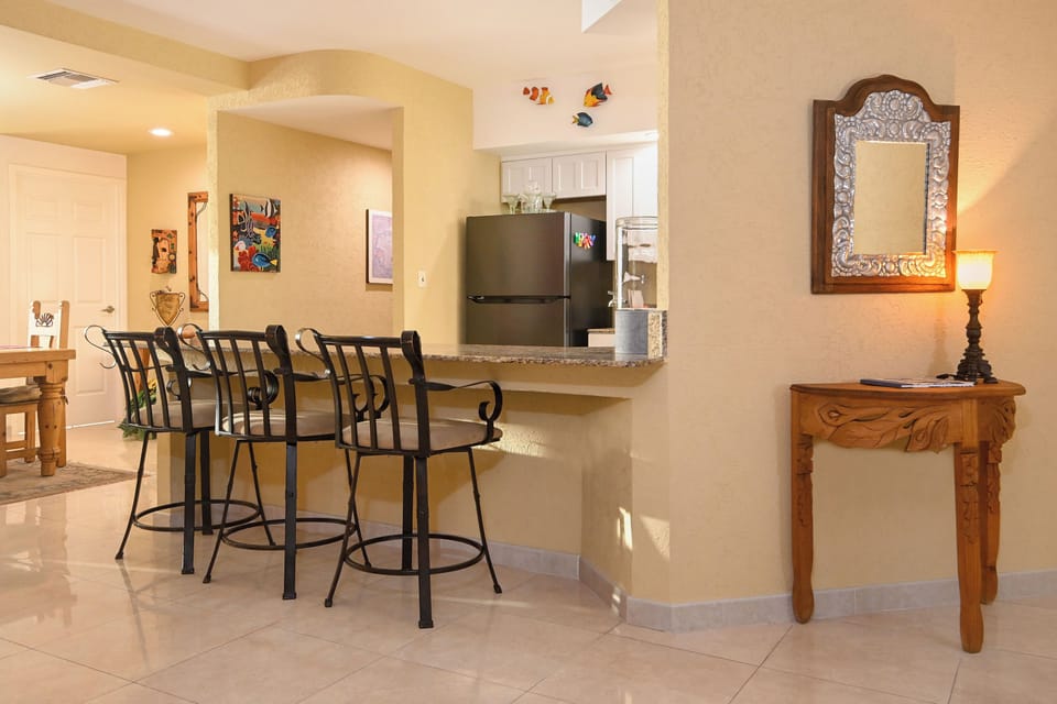 Gather at the breakfast bar for morning coffee or casual meals, with a fully equipped kitchen just steps away, bright open space, and thoughtful touches throughout.
