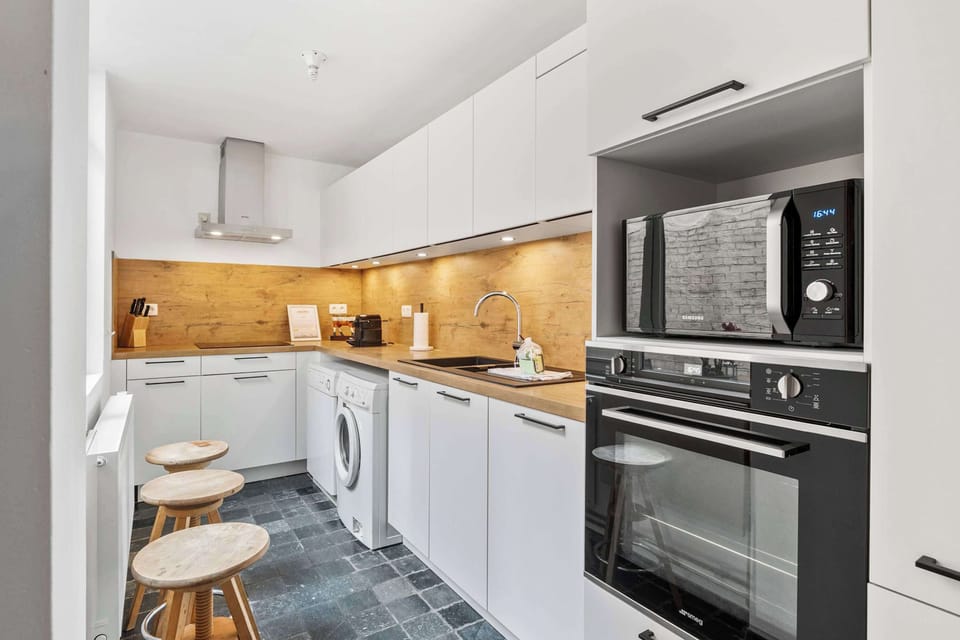 Fully equipped modern kitchen with a Smeg oven, induction hob, microwave, washing machine and Nespresso. Everything you need for self-catering in this central Bruges holiday home.