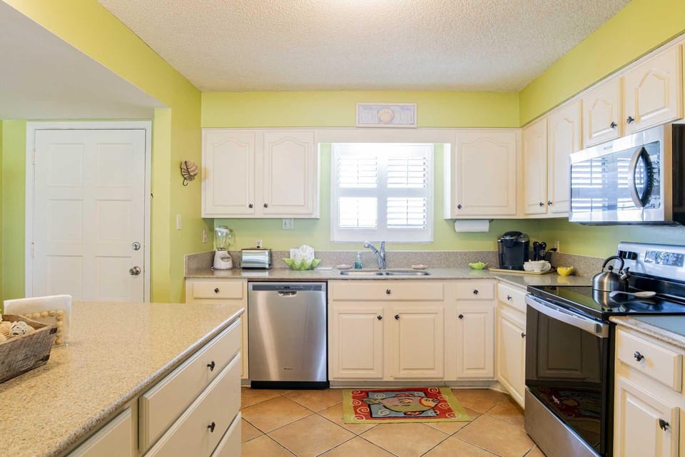 Bright, airy kitchen with modern appliances and cheerful yellow walls
