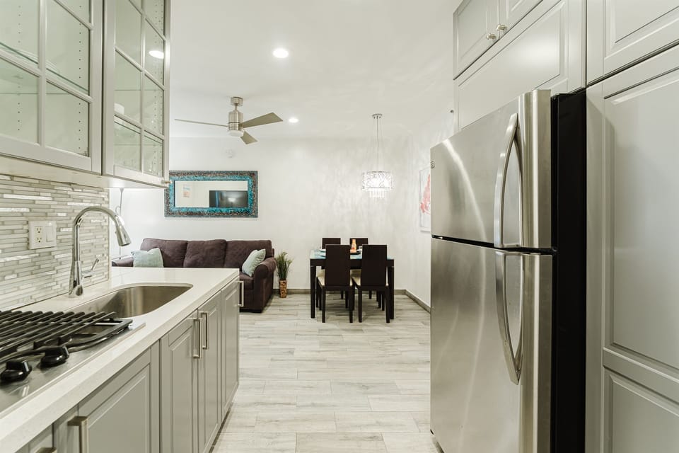 Fully equipped kitchen with modern finishes, cookware, and everything needed for preparing meals, seamlessly connected to the living and dining areas. (Gas stove is not operational- a 3-burner stove is available)
