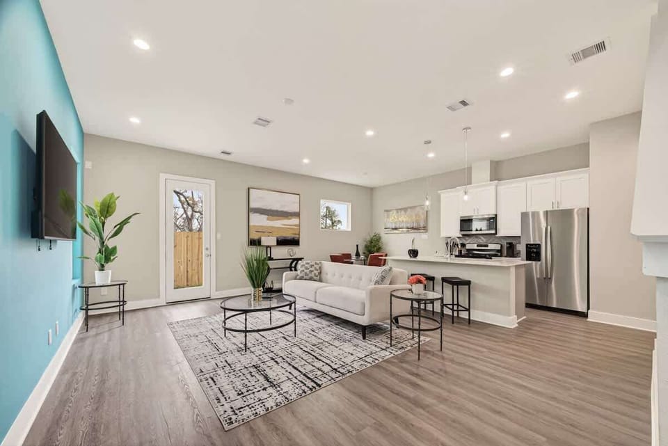 Modern open-concept living room and kitchen with large island and comfy seating.