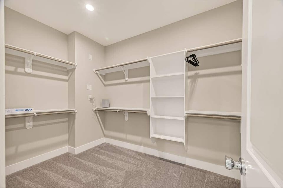 Large walk-in closet featuring custom built-in shelves. The perfect dedicated space to keep your stay clutter-free.