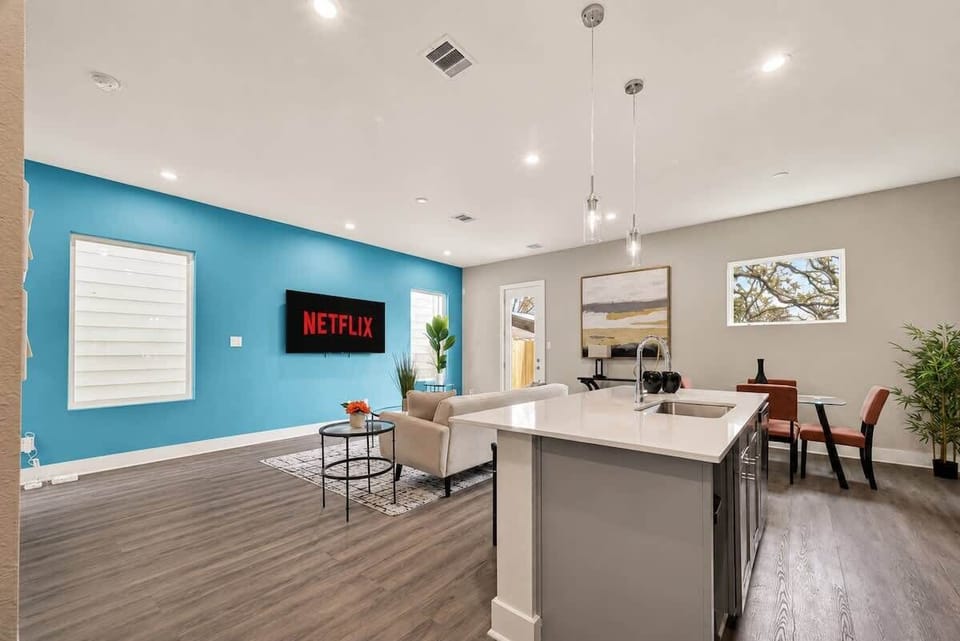Modern open-concept living room and kitchen with large island and comfy seating.