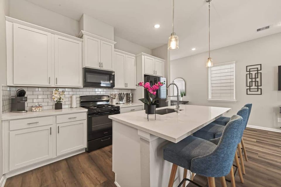 Bright, open-concept kitchen with a large quartz island and deep sink, perfect for entertaining while staying connected to the living area.