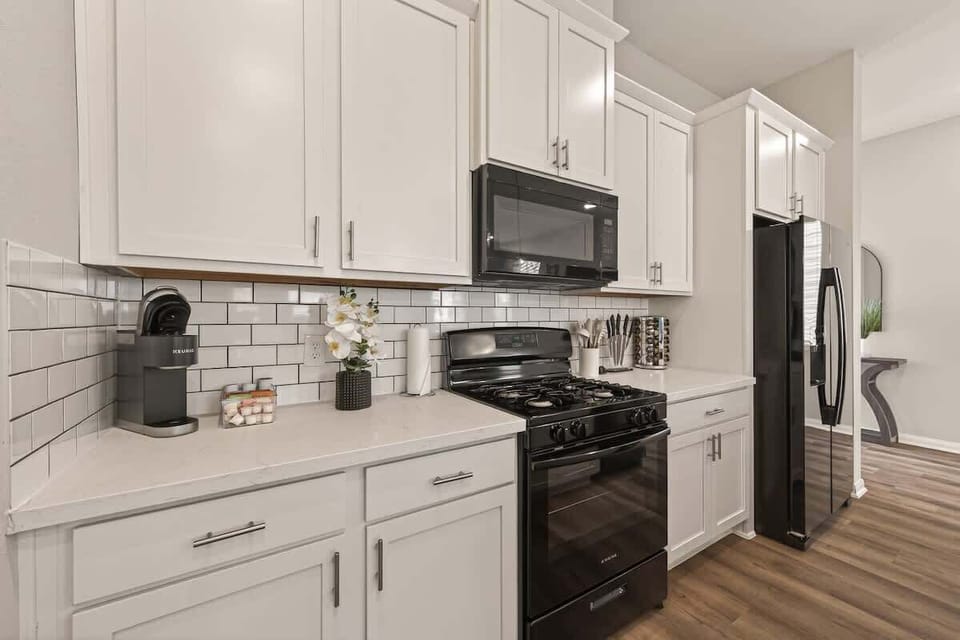 Start your day right at the Keurig coffee station in this bright, fully stocked kitchen with sleek white cabinetry and quartz-style countertops.