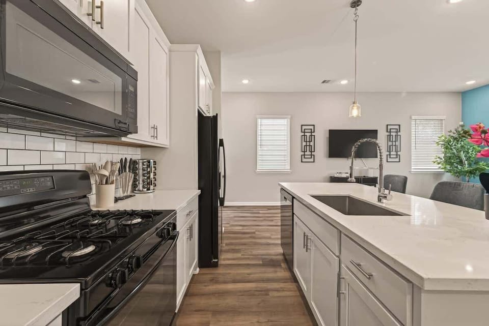 Bright, open-concept kitchen with a large quartz island and deep sink, perfect for entertaining while staying connected to the living area.