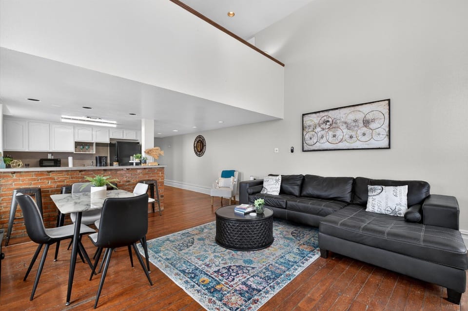 Vaulted ceilings and exposed brick in open living space.