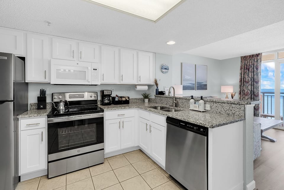 Bright coastal kitchen with granite counters and stainless appliances
