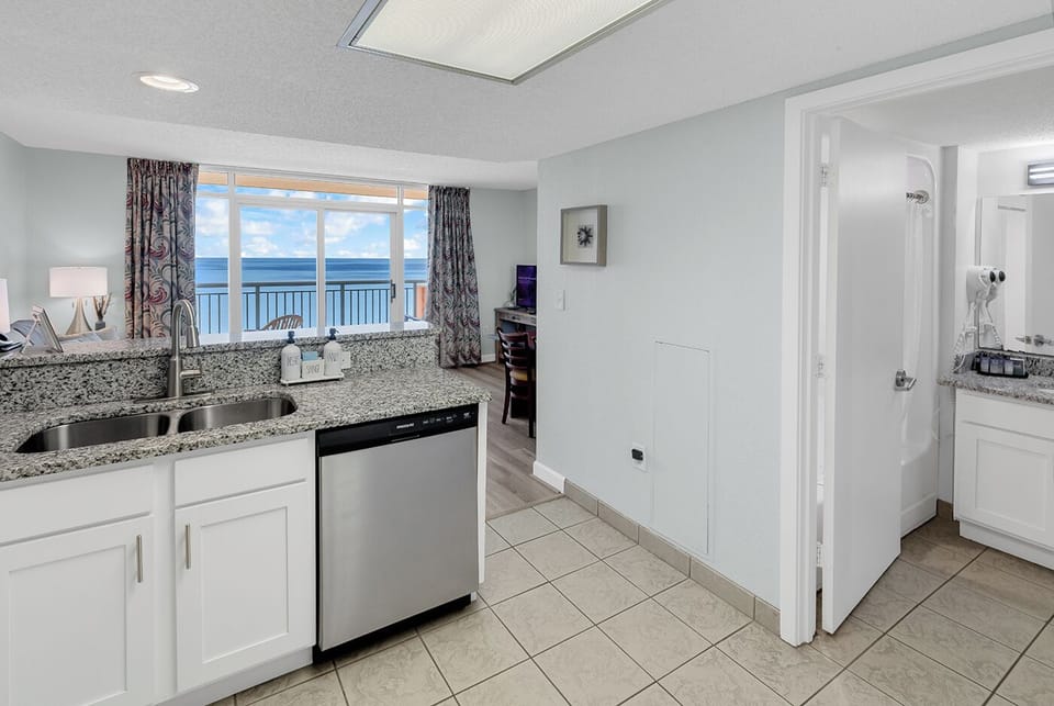 Bright coastal kitchen with granite counters and stunning ocean views