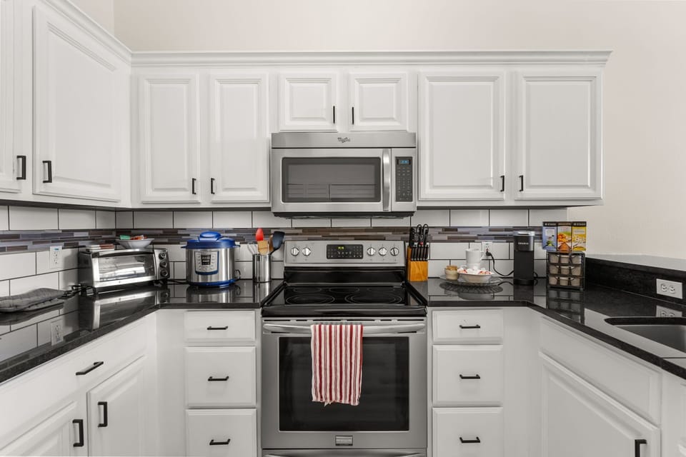 Prepare everything from quick breakfasts to family feasts in this spacious, fully equipped kitchen featuring stainless steel appliances, ample counter space, and all the essentials for a comfortable stay.