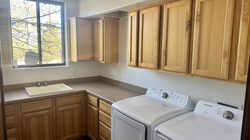 Full size launsry room with Washer, dryer, and deep sink