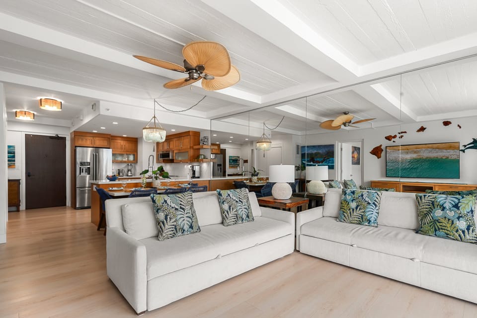 Spacious open living area featuring plush sectional seating, coastal décor, and a seamless flow into the modern kitchen.