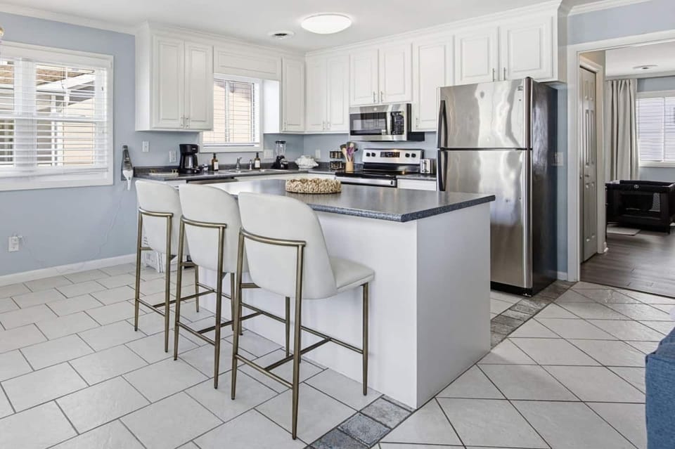 Fully equipped kitchen with bar seating, stainless steel appliances, and everything you need to cook at home