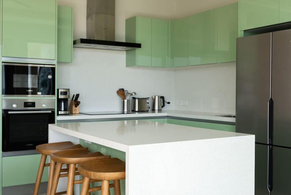 Modern kitchen with green accents and breakfast bar
