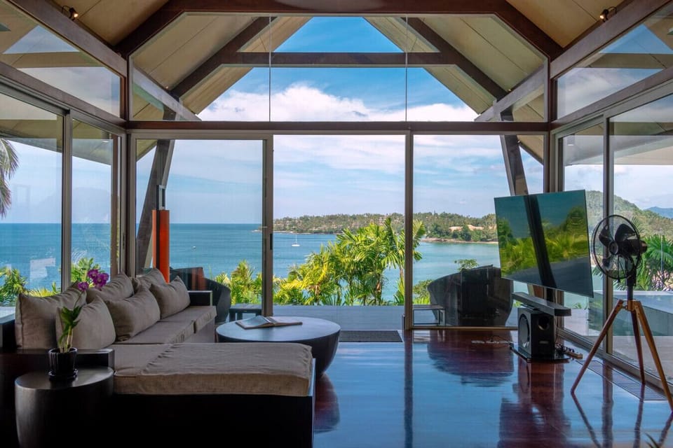 Breezy open-plan living space with vaulted timber ceiling and ocean panorama at Surin Beach villa