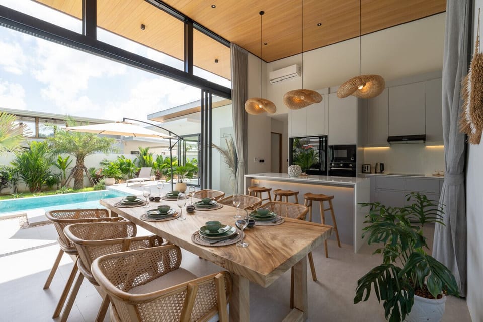 Bright dining area in Bophut holiday villa with wooden table rattan chairs and tropical garden views