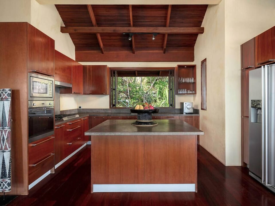 Fully equipped gourmet kitchen with dark wood cabinetry and modern appliances at Soluna