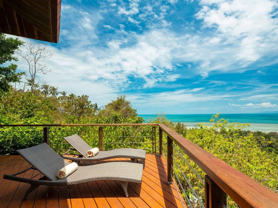 Hillside infinity pool with Gulf of Thailand views and sun loungers at Soluna 2BR villa