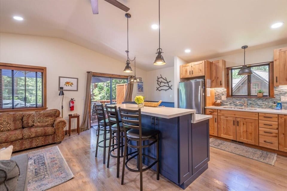 Spacious great room with vaulted ceilings, living area, gas fireplace, 50 inch SmartTV, dining area, kitchen and direct access to front deck.