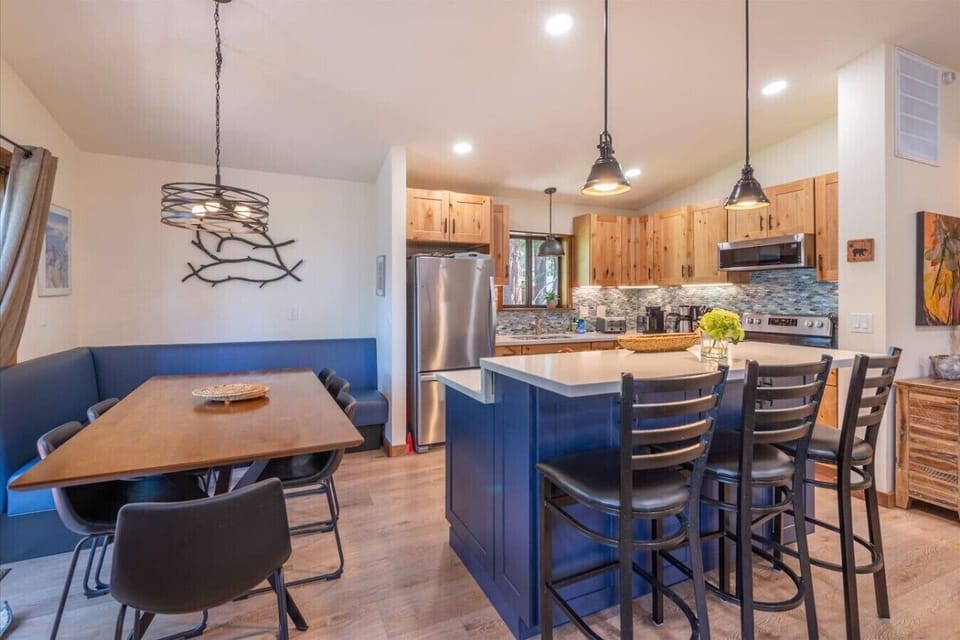 Spacious great room with vaulted ceilings, living area, gas fireplace, 50 inch SmartTV, dining area, kitchen and direct access to front deck.