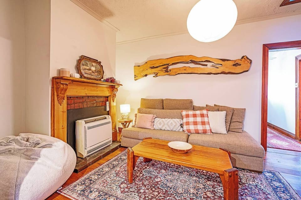 Unwind in the second living area, a cosy retreat with soft furnishings and heritage charm that invites slow mornings with a coffee or peaceful evenings indoors.