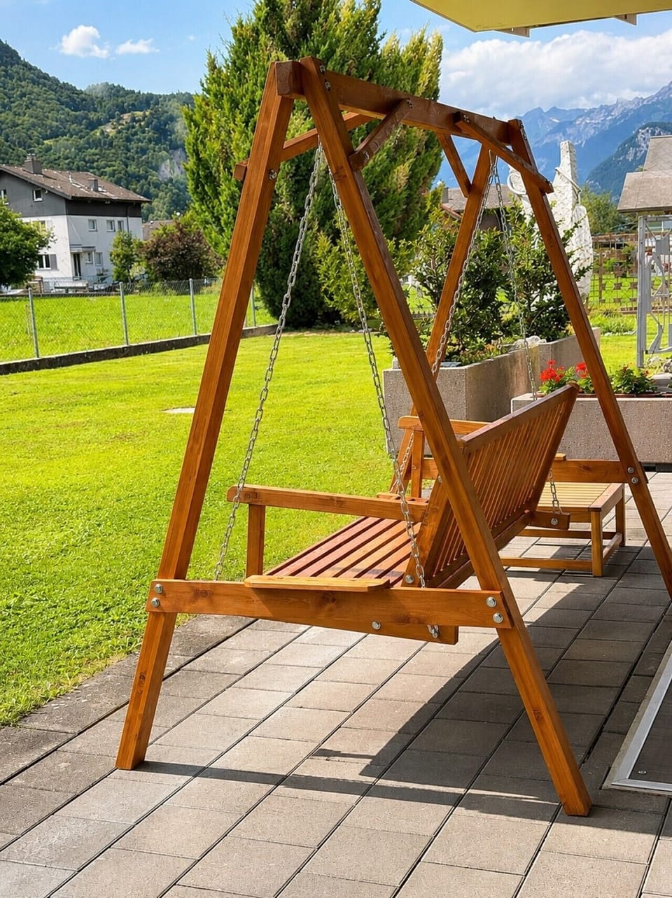 Chalet Swiss Dream Manor garden swing — ground-floor Manor 2 terrace seating with private lawn, fresh alpine air and Meiringen mountain views.