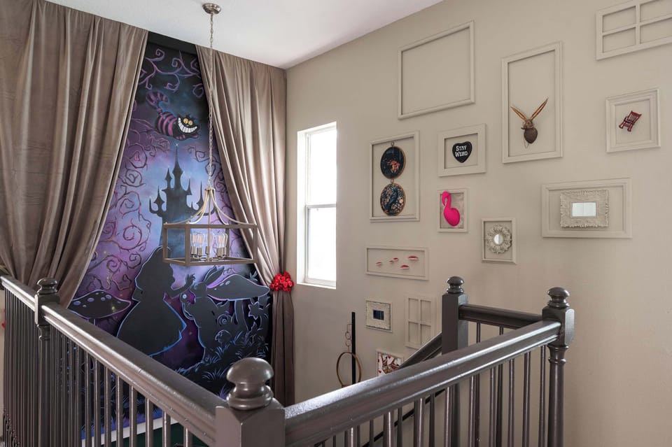 A whimsical stairwell features a colorful mural and eclectic wall art for a playful atmosphere.