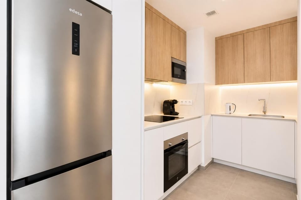 A modern kitchen and dining area with warm wooden cabinetry and elegant neutral decor.