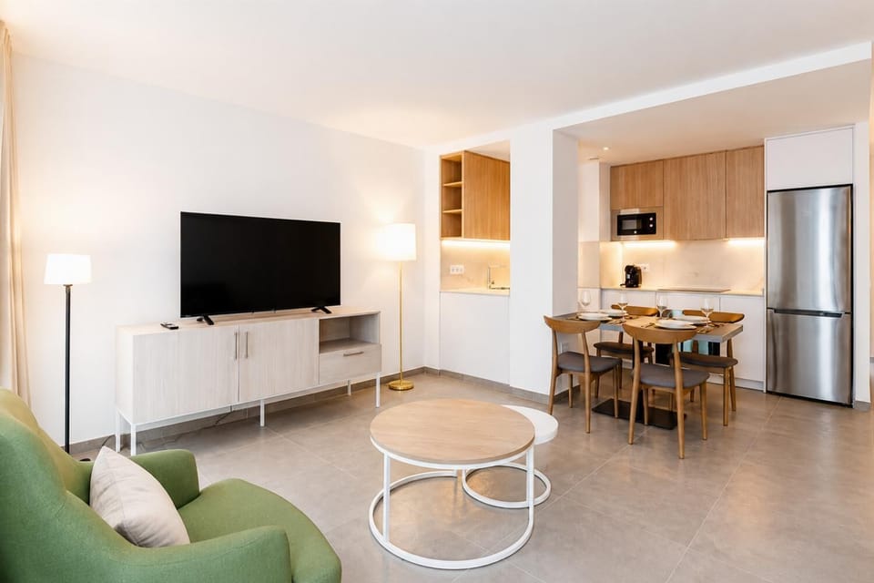 A modern kitchen and dining area with warm wooden cabinetry and elegant neutral decor.