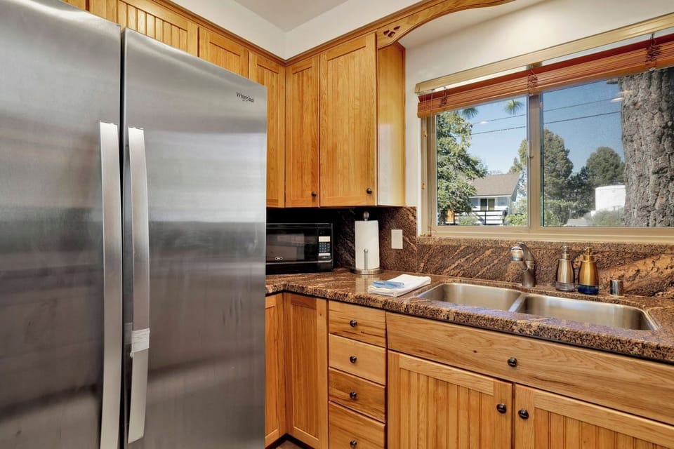 Bright kitchen with granite counters, double sink, and stainless fridge