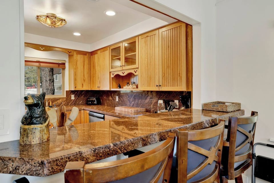 Rustic kitchen with granite bar seating and warm wood cabinetry
