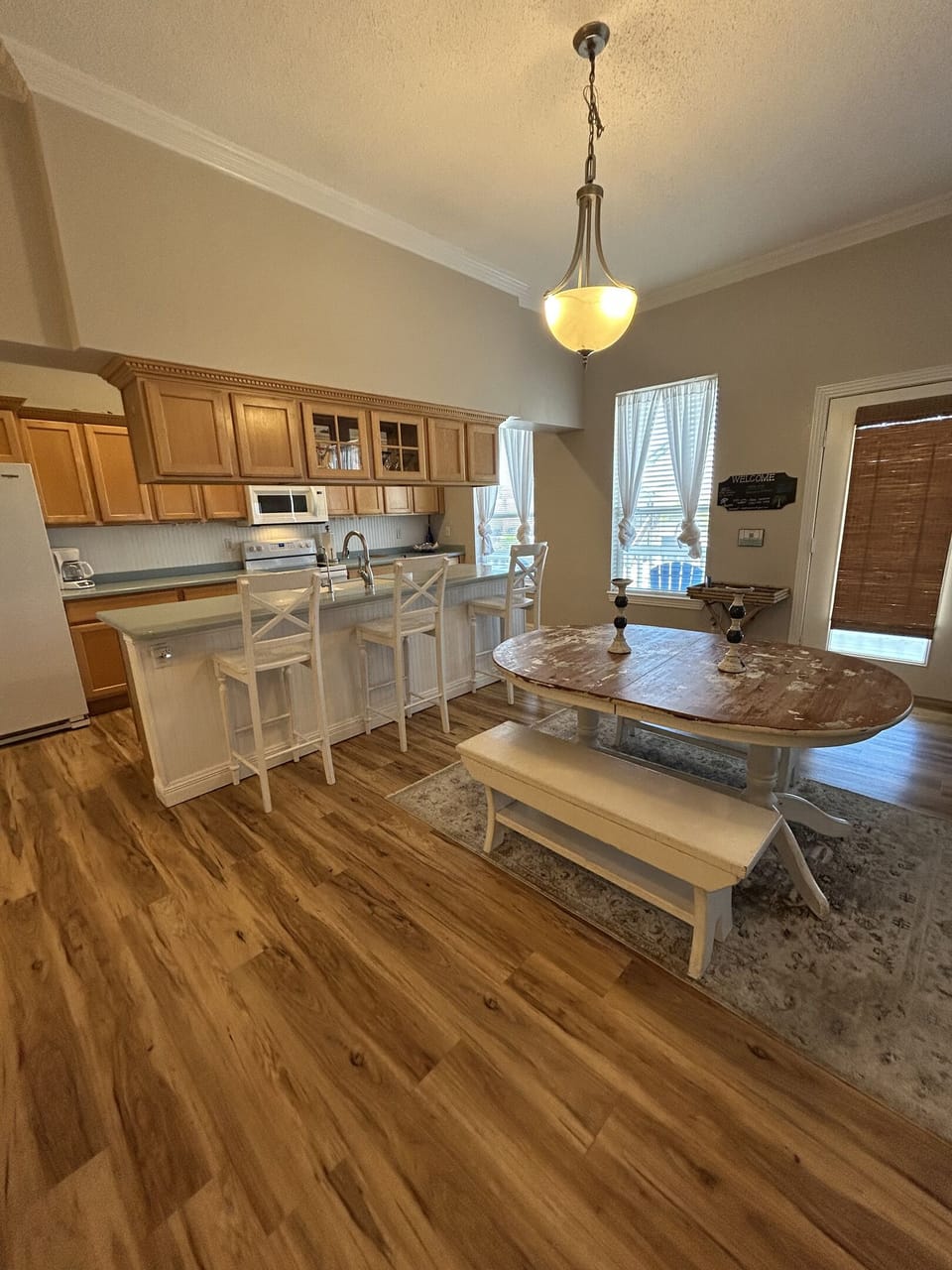The spacious kitchen island provides extra prep space and casual seating for quick breakfasts or afternoon snacks. Just steps away, the farmhouse-style dining table with bench seating comfortably accommodates your group for memorable meals together.