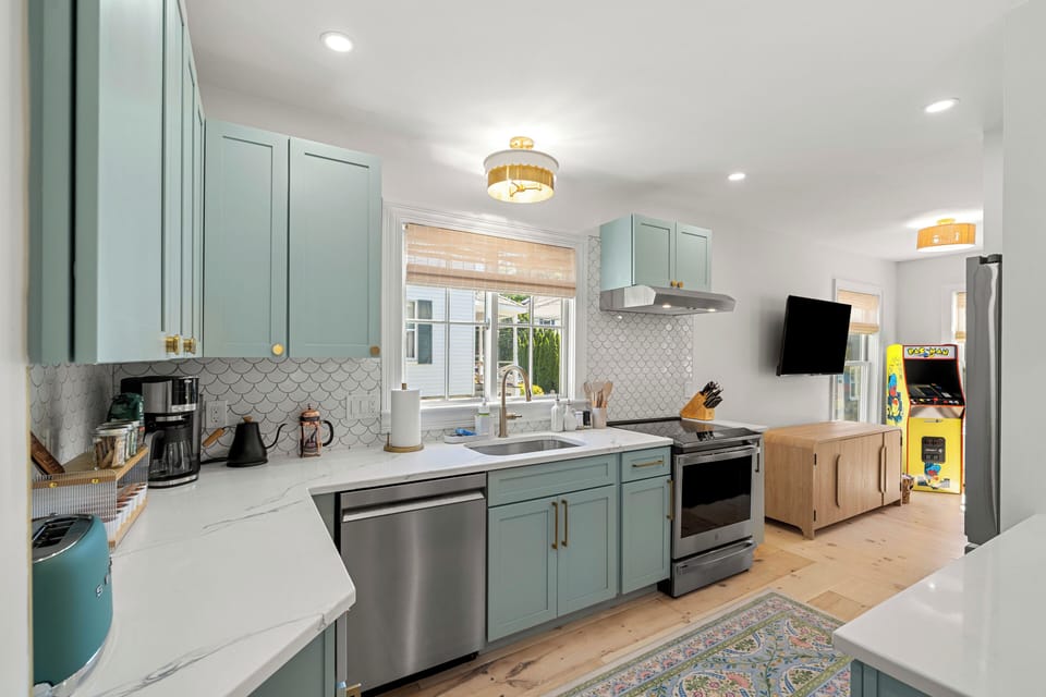 Bright coastal kitchen with custom cabinetry and scalloped tile details.