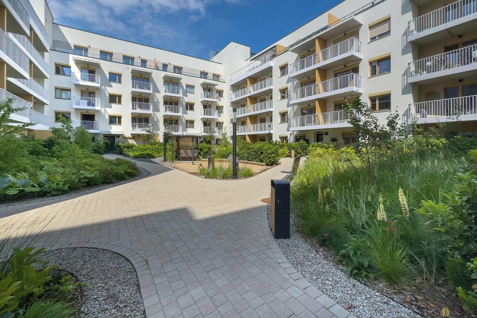 Modern apartment building surrounded by landscaped greenery.