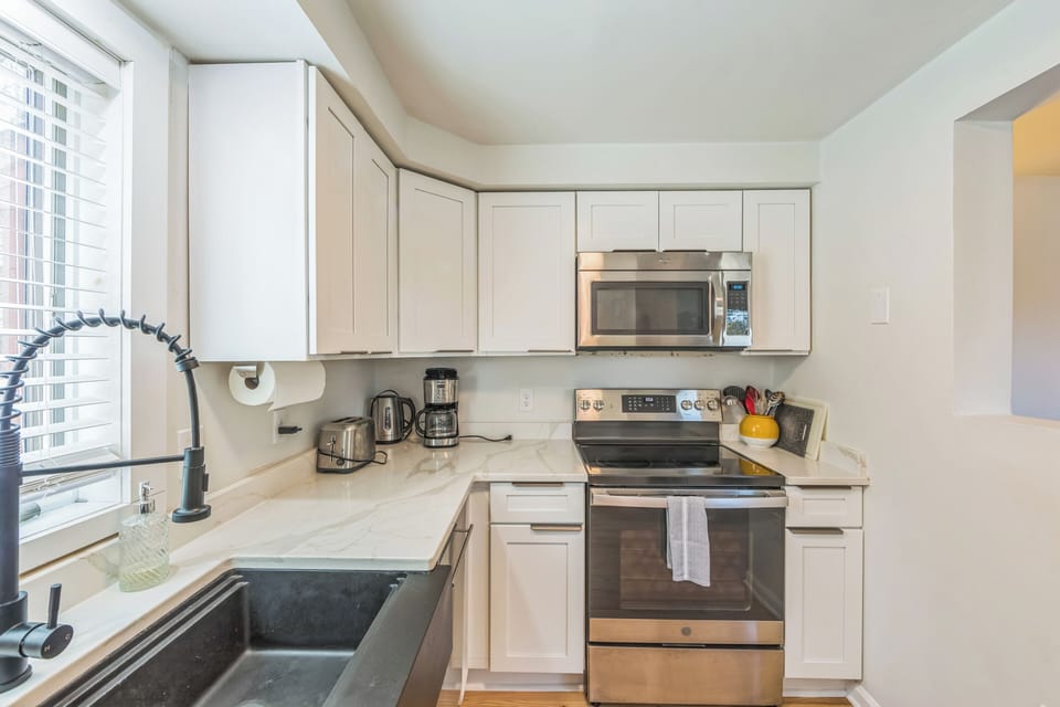 Bright and functional kitchen featuring ample counter space, a built-in microwave, and modern finishes.